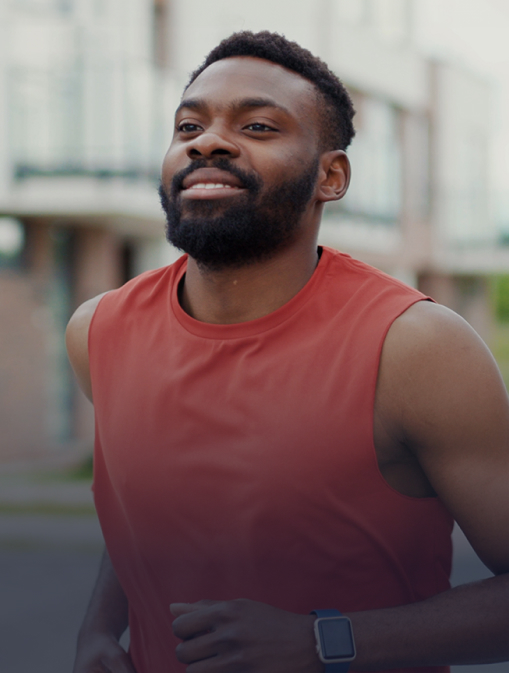 A man is sitting on his bed and stretching in front of the window