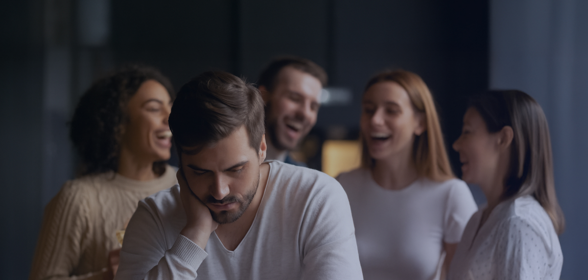 A man is sitting on his bed stretching in front of the window
